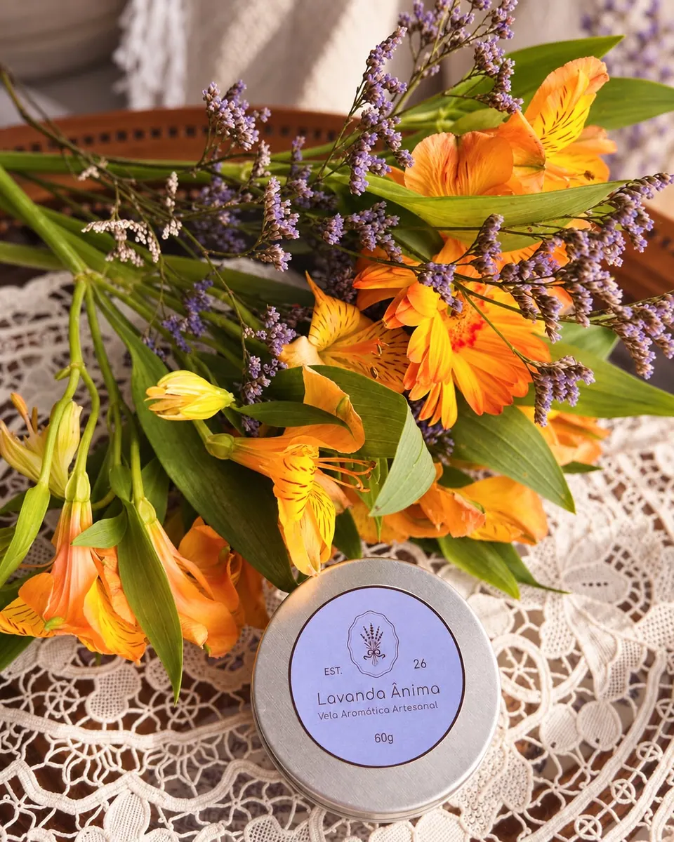 Vela Lavanda Ânima de 60 g apresentada junto a flores alaranjadas e lilases